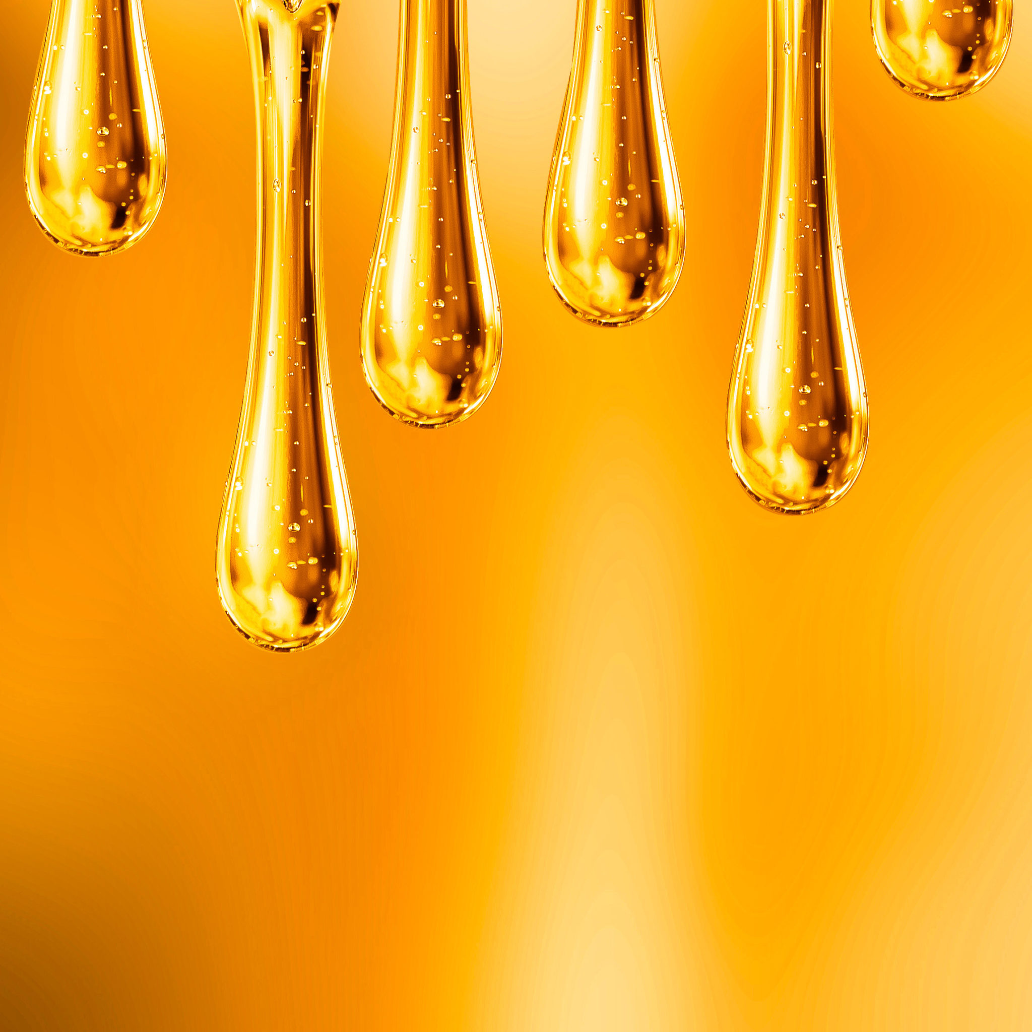 Goldgelbe, transparente Pflegetropfen mit kleinen Bläschen vor orangefarbenem Hintergrund – Symbolbild für rückfettende Wirkstoffe wie PCA Glyceryl Oleate