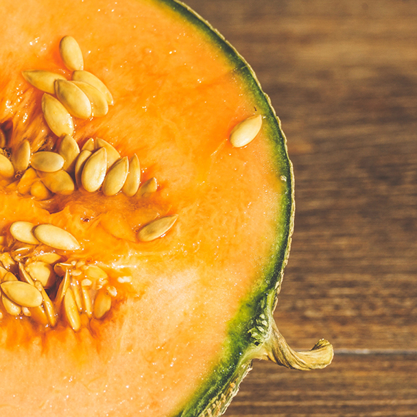 Halbe aufgeschnittene Zuckermelone mit orangefarbenem Fruchtfleisch und Kernen – Quelle für Cucumis Melo (Melon) Fruit Extract.