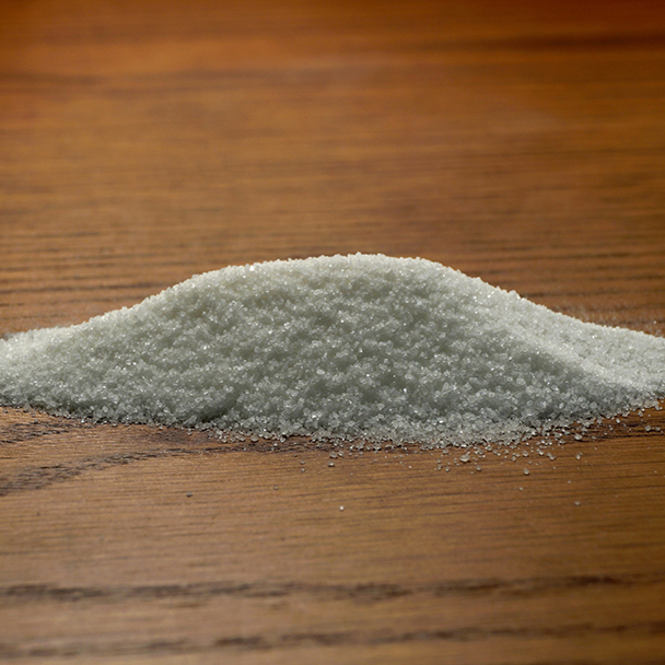 Heller, feinkörniger Menthyl-Lactate-Pulverhaufen auf einer Holzoberfläche