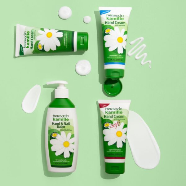 Vier verschiedene Herbacin Kamille Handpflegeprodukte auf grünem Hintergrund mit aufgetragener Produkttextur – Creme, Balsam und Hand & Nail Balm.