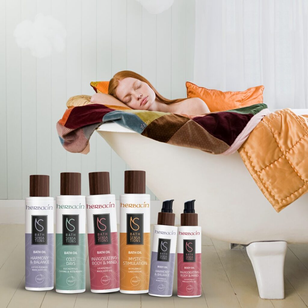 herbacin-bath-seas-body-oil-frau-in-badewanne Junge Frau schläft entspannt in einer Badewanne, davor Herbacin Bath Sensations und Body Oil Produkte für Wellness und Hautpflege.